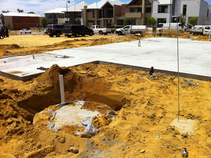 Concrete soakwell being installed by excavator.